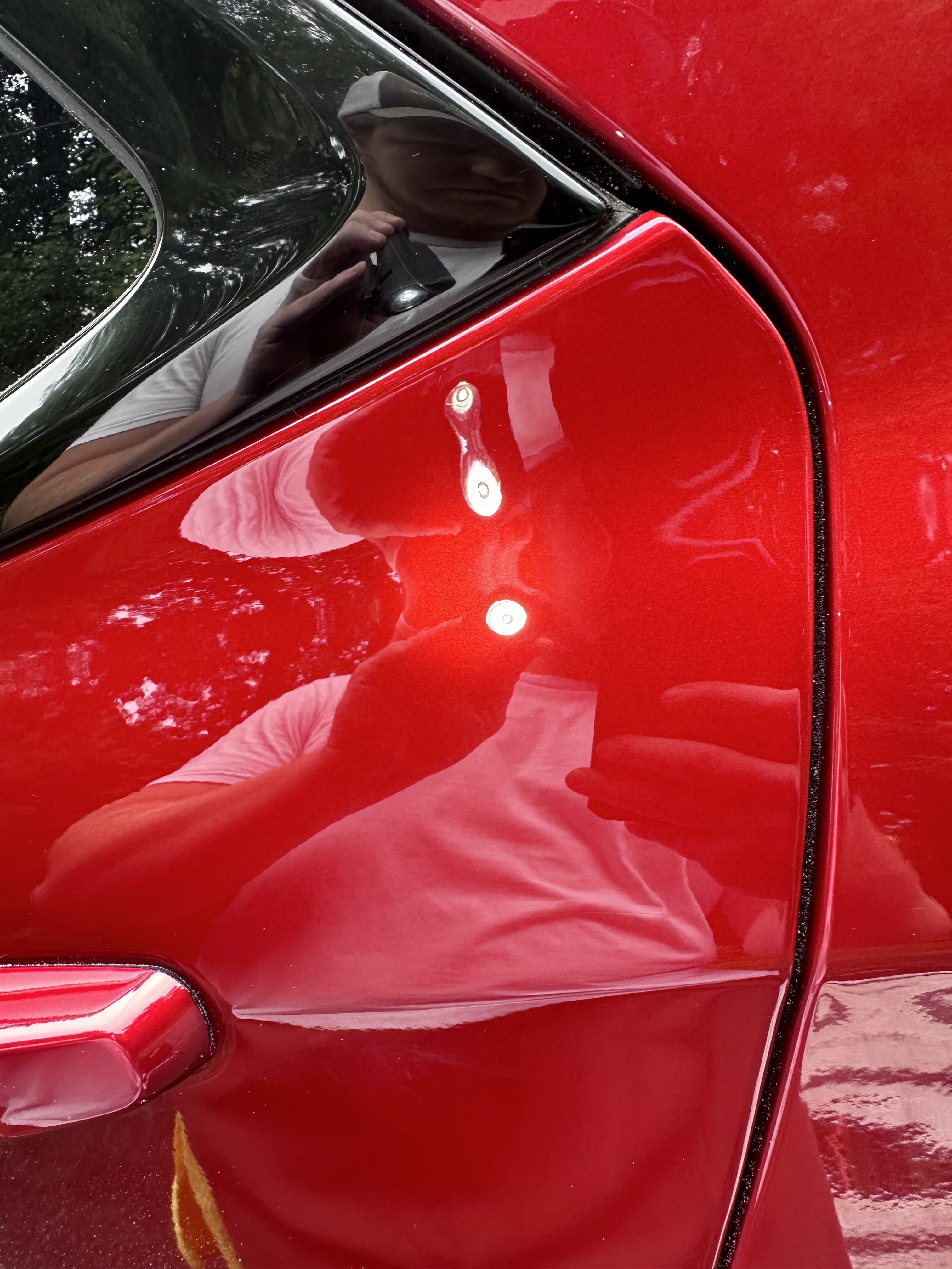 The same red car paint polished to a clear, glossy finish after paint correction