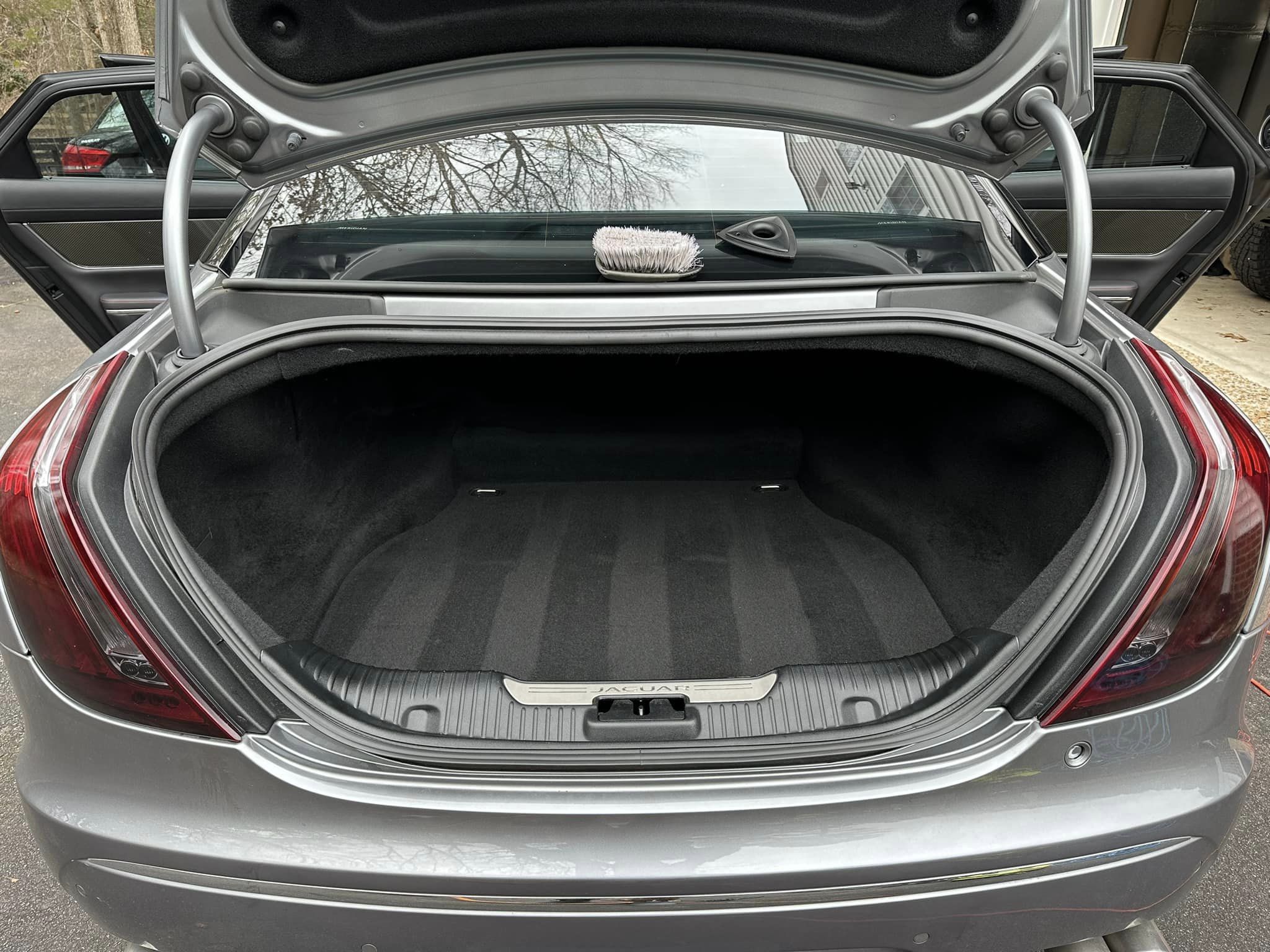 Rear trunk of a silver Jaguar, meticulously detailed