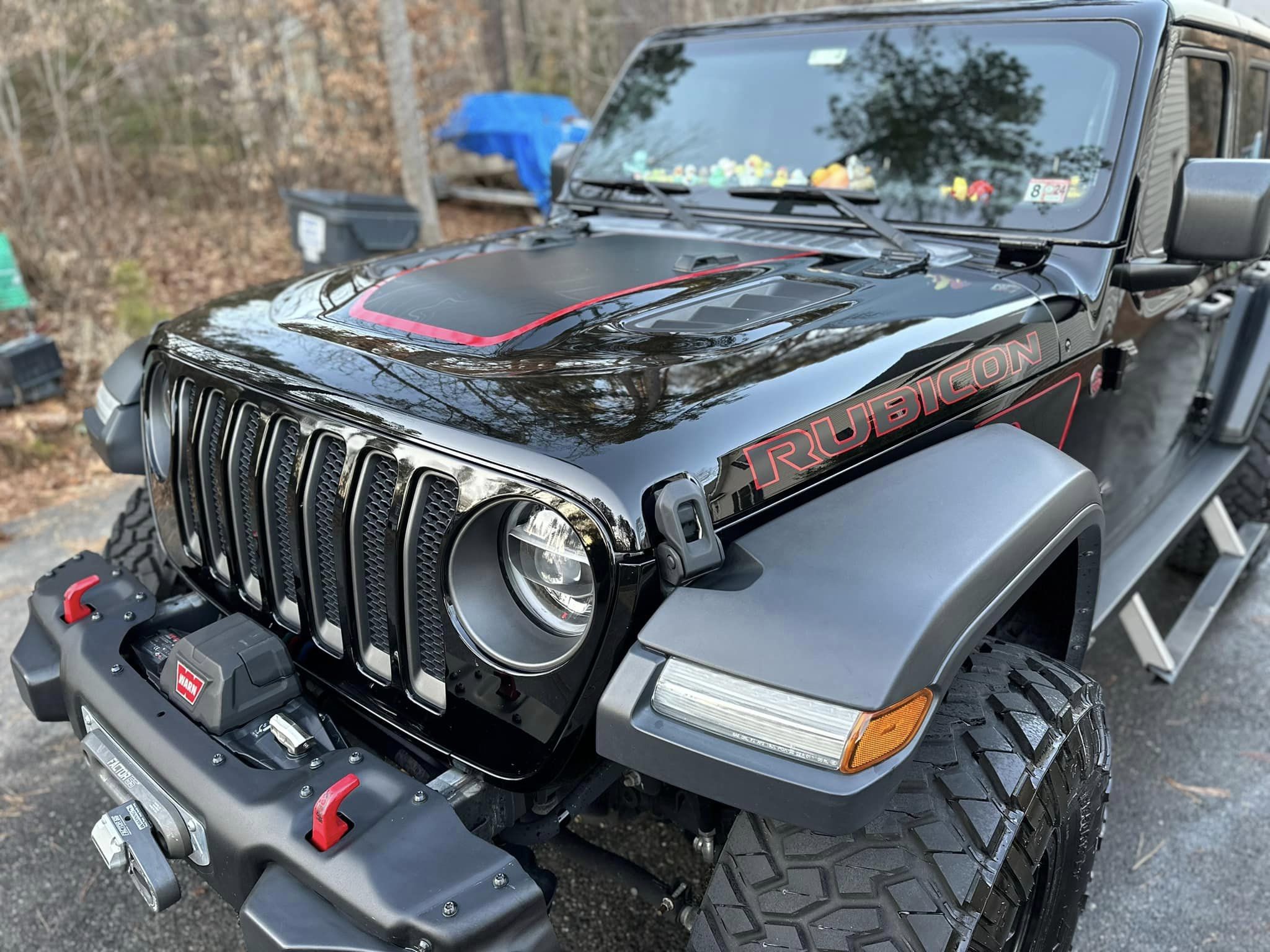 Front quarter panel of a detailed black Jeep Wrangler with a front tow winch
