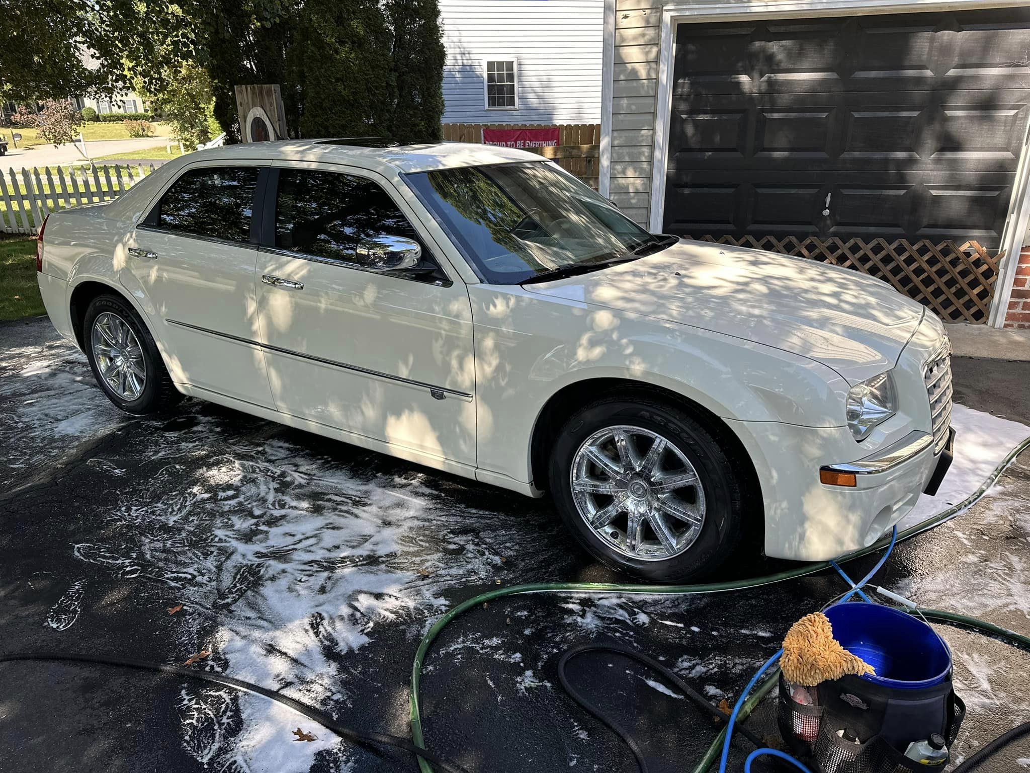white car freshly washed with suds on the ground