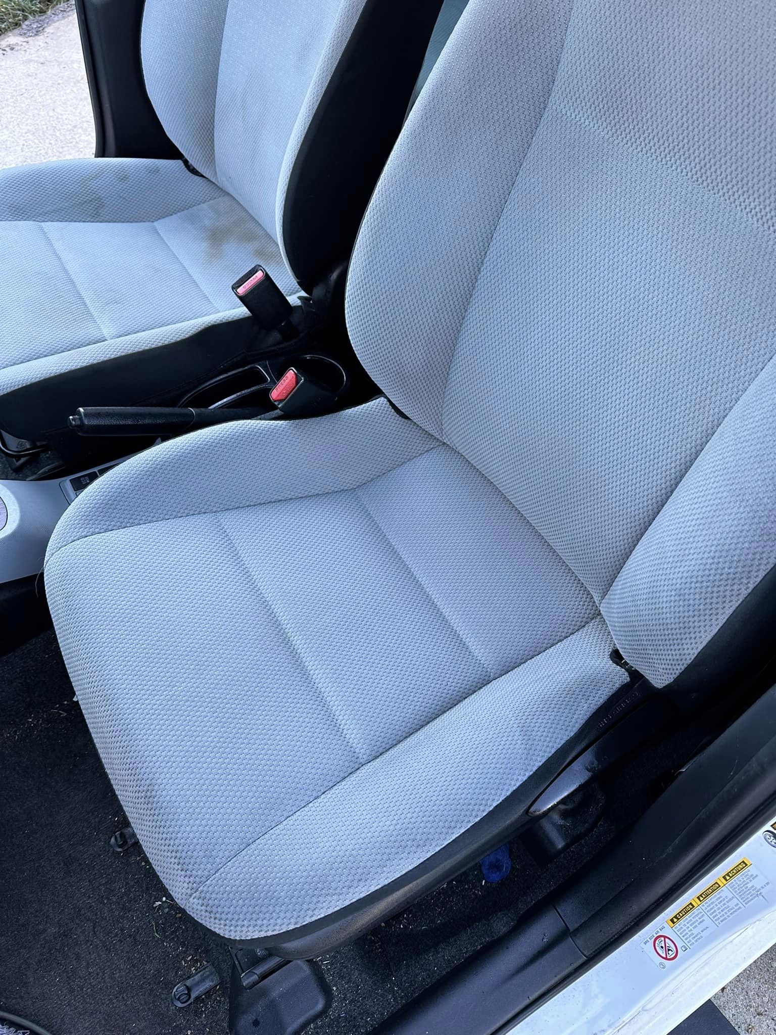 The same white car seat clean and bright after shampooing and steam cleaning